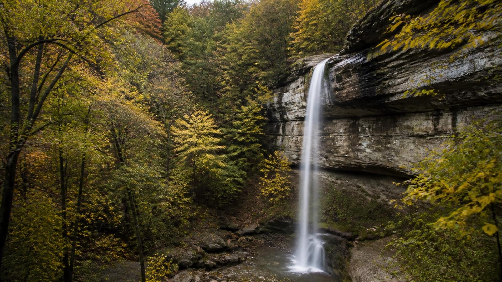 Tall waterfall dropping over sandstone bluffs in the Arkansas Ozarks